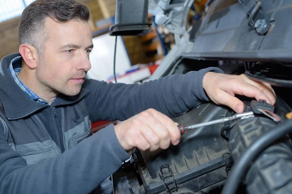 Mecánico trabajando en un motor en el garaje de reparación — Foto de Stock