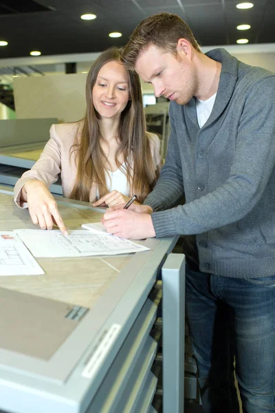Ungt par som planlegger et nytt kjøp – stockfoto