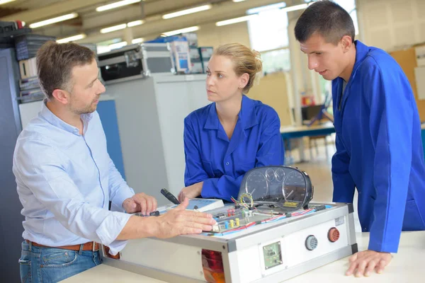 Students with teacher looking at electical unit — Stock Photo, Image
