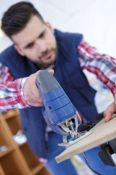 Homem cortando bloco de madeira com fretsaw — Fotografia de Stock