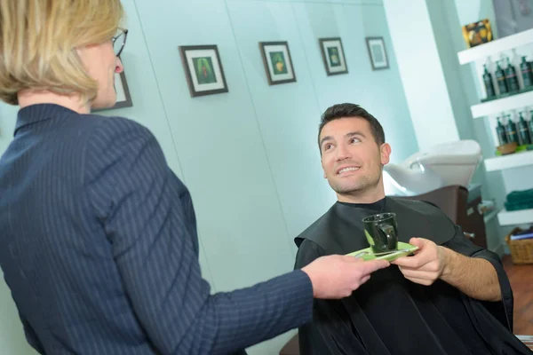 Glücklicher Mann trinkt Kaffee beim Friseur — Stockfoto