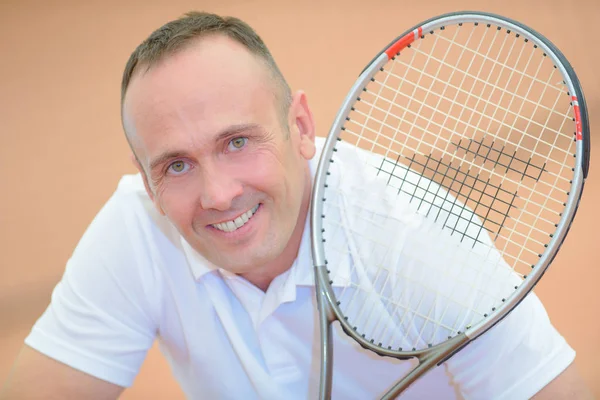 Retrato de un hombre de mediana edad sosteniendo raqueta de tenis — Foto de Stock