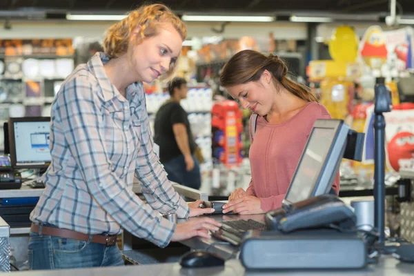 Kvinnliga kunden betalar kassan med terminal i stormarknad — Stockfoto