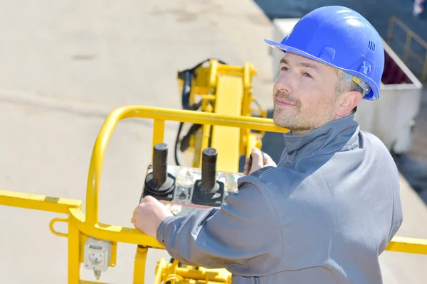 Hombre controlando una máquina de color amarillo — Foto de Stock