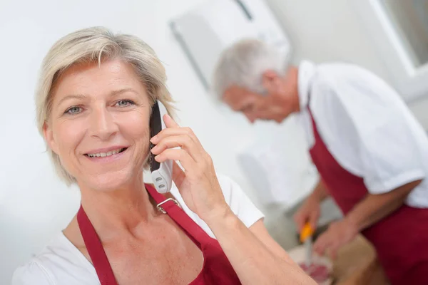 Dame aan de telefoon en schort — Stockfoto