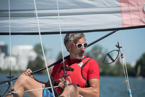 Bello giovane seduto su un gatto hobie — Foto Stock