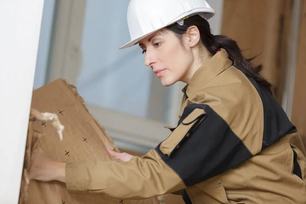 Mujer constructor quitar una parte de la pared — Foto de Stock