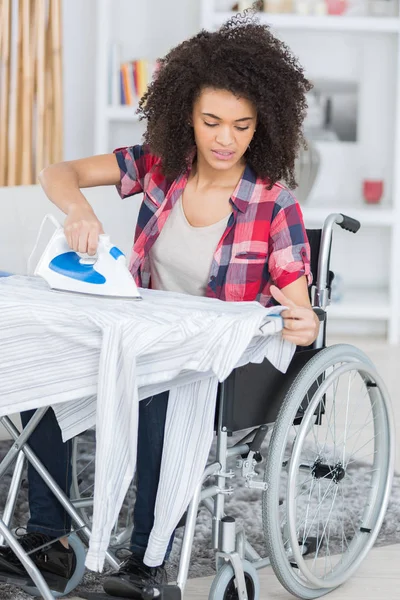 Beautiful disabled woman ironing — Stock Photo, Image