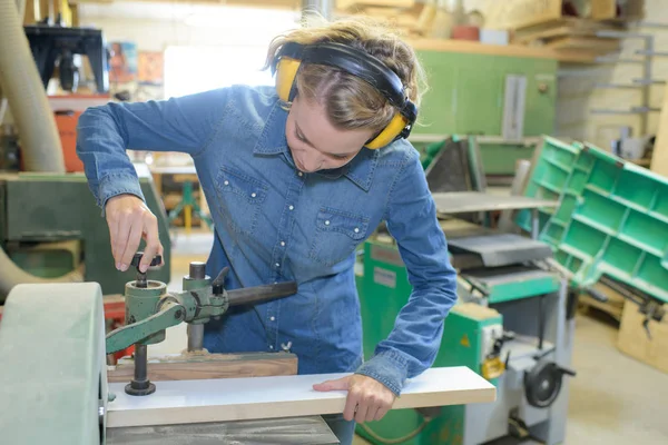 Kadın marangoz odun için elektrikli zımpara makinesi kullanıyor. — Stok fotoğraf