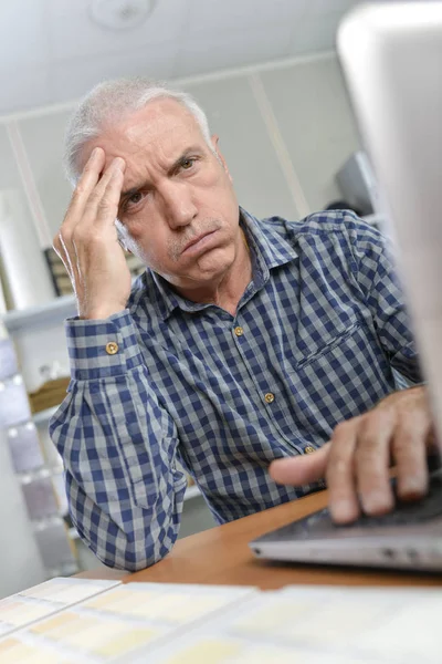 Hombre frunciendo el ceño en el portátil — Foto de Stock