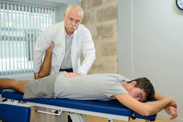 Physiothérapeute travaillant avec le patient à la clinique — Photo