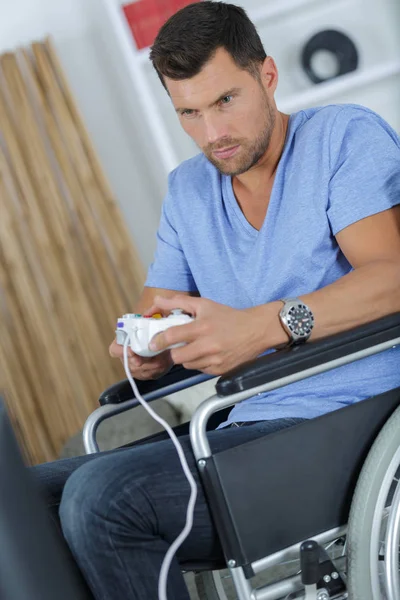 Homem em cadeira de rodas jogando jogo de computador — Fotografia de Stock