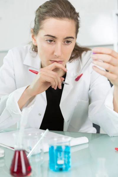 Serieus op zoek vrouwelijke arts met bloed sonde en aanvraag formulier — Stockfoto