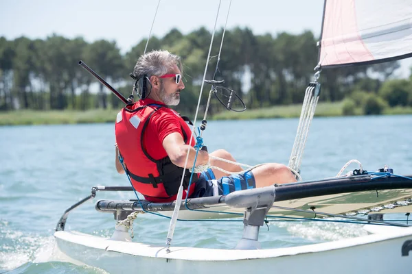 Mann segelt mit Segeln an einem sonnigen Tag — Stockfoto