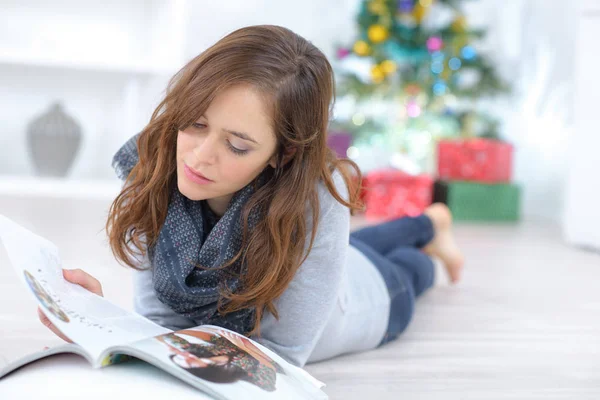 Młoda brunetka kobieta leżący na podłodze podczas czytania — Zdjęcie stockowe