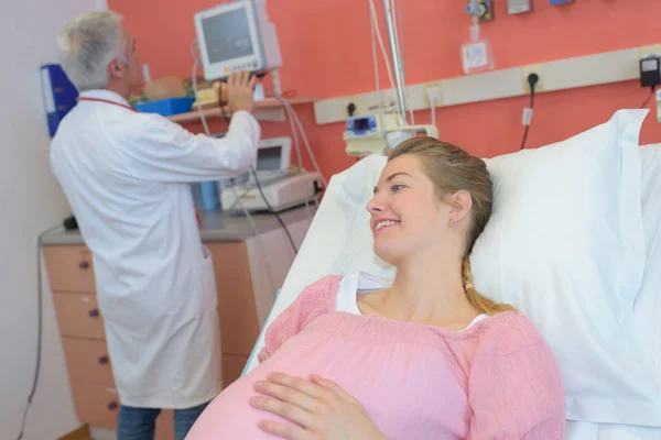 Врач делает УЗИ живота беременной женщины в клинике — стоковое фото