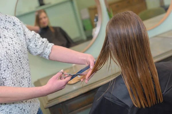 Vrouwelijke Kapper houden tussen vingers blonde haren — Stockfoto