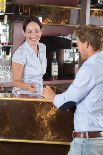Affärsman som talar till barflicka i en bar — Stockfoto
