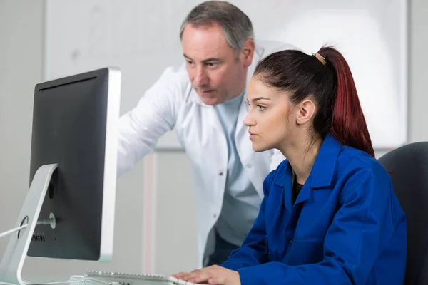 Pretty young woman learning how to use computer — Stock Photo, Image