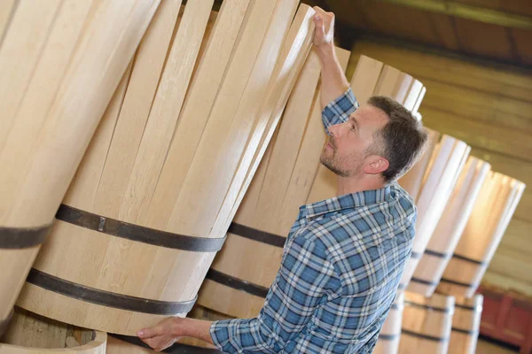 wood barrels production cooper using hammer and tools in workshop