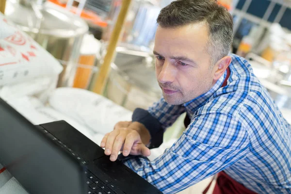 Foreman werken met laptop in fabriek — Stockfoto
