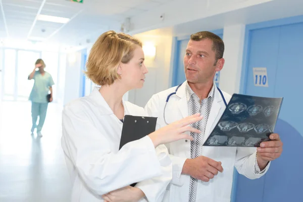 Médico masculino y femenino mirando la radiografía del paciente Imagen De Stock