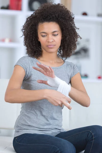 Vrouw inwikkeling haar pols — Stockfoto