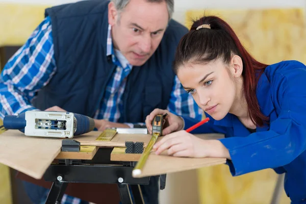 Handledare titta på unga damen använda måttband — Stockfoto