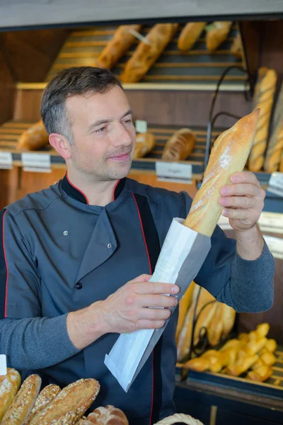 Panadería tendero está orgulloso de su producción de pan —  Fotos de Stock