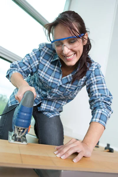 Magabiztos női carpenter segítségével szalagfűrész portréja — Stock Fotó