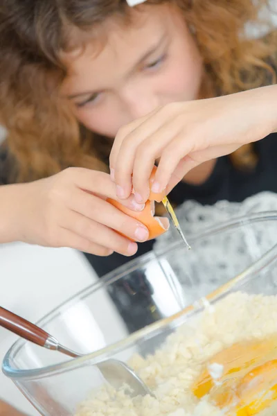 Kind bricht Ei in Schüssel — Stockfoto