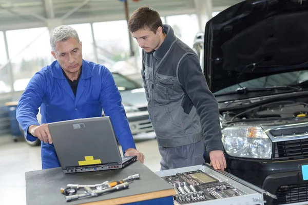 Profesor mecánico de automóviles y aprendiz realizando pruebas en la escuela de mecánica —  Fotos de Stock