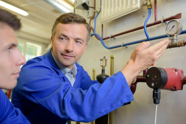 Tradesman showing apprentice an inline dial — Stock Photo, Image