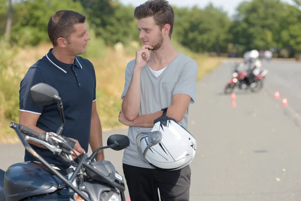 Joven hablando con instructor del curso de entrenamiento de motocicletas — Foto de Stock