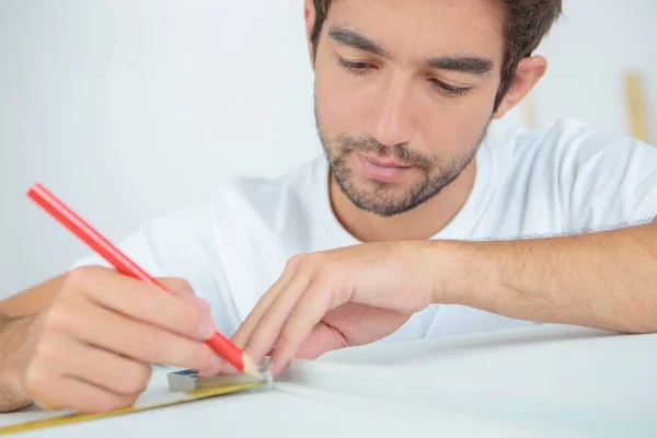 Man marking an object with pencil — стоковое фото