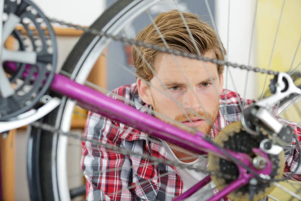 Handyman fixação roda de bicicleta em sua garagem — Fotografia de Stock