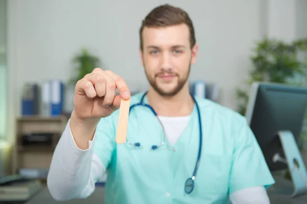 Junger Arzt untersucht die Kehle eines Patienten — Stockfoto