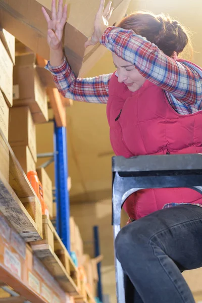 Scatola di cartone che cade sul lavoratore femminile nel magazzino — Foto Stock