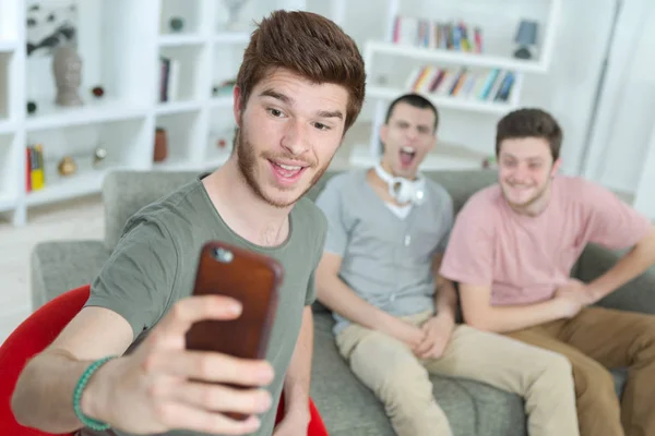 Hombres jóvenes tomando una foto loca — Foto de Stock