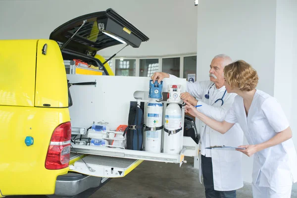 Medico che controlla i serbatoi di ossigeno in ambulanza — Foto Stock