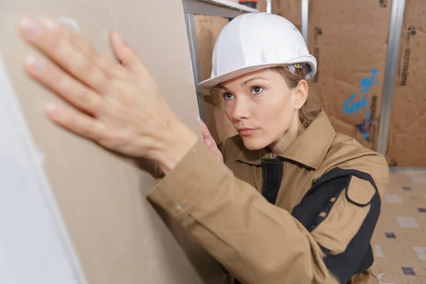 Ung kvinnlig builder arbetar inomhus — Stockfoto