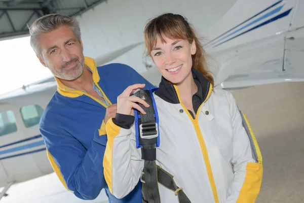 Portrait of man and woman in jumpsuits next to aircraft — Stock Photo, Image