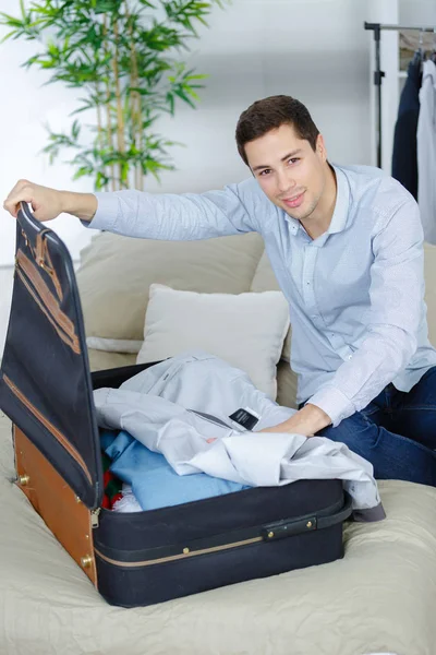 Gros plan de l'homme d'affaires emballant des vêtements dans un sac de voyage — Photo