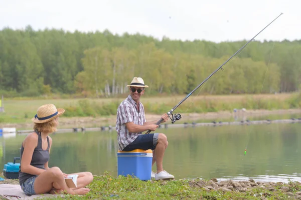 快乐的夫妻在池塘边钓鱼 — 图库照片