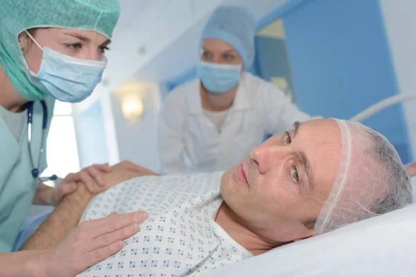 Enfermera inspeccionando a un paciente moribundo — Foto de Stock