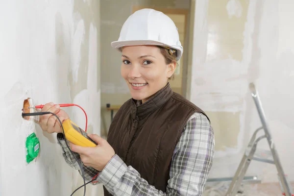 Eletricista fêmea instalar uma tomada de parede — Fotografia de Stock