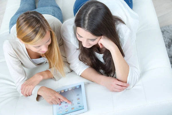 Amigos femininos felizes com computador tablet pc em casa — Fotografia de Stock