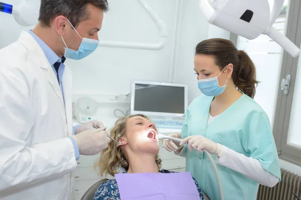 Happy male dentist with assistant and female patient — Stock Photo, Image