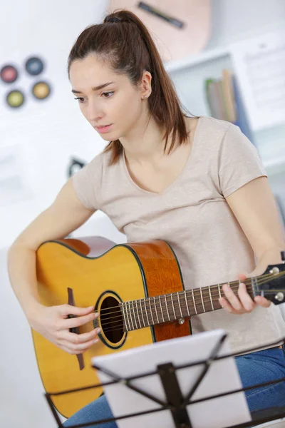 Mädchen spielt Gitarre im Wohnzimmer — Stockfoto