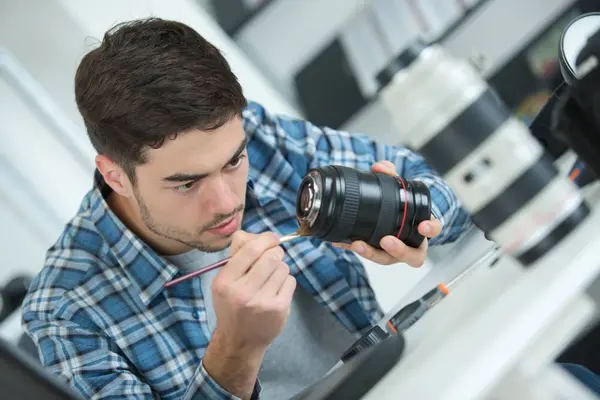 Junger attraktiver Mann fixiert DSLR-Kameralinse — Stockfoto